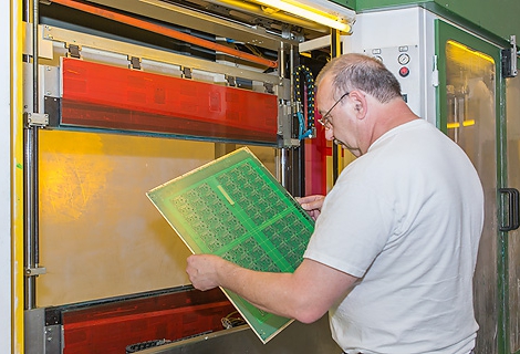 Solder resist is being applied in vertical silkscreen printing